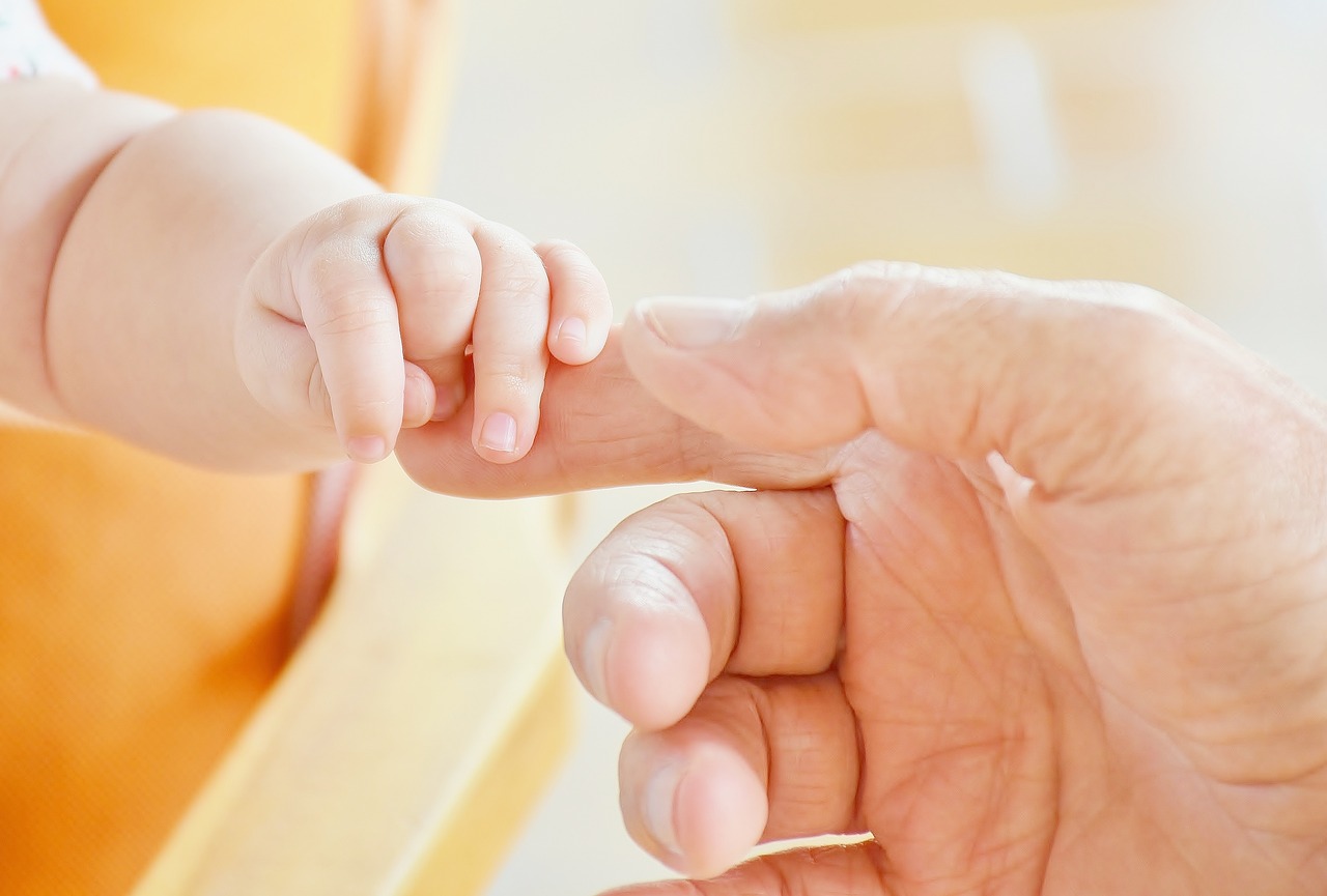 man holding baby hands 