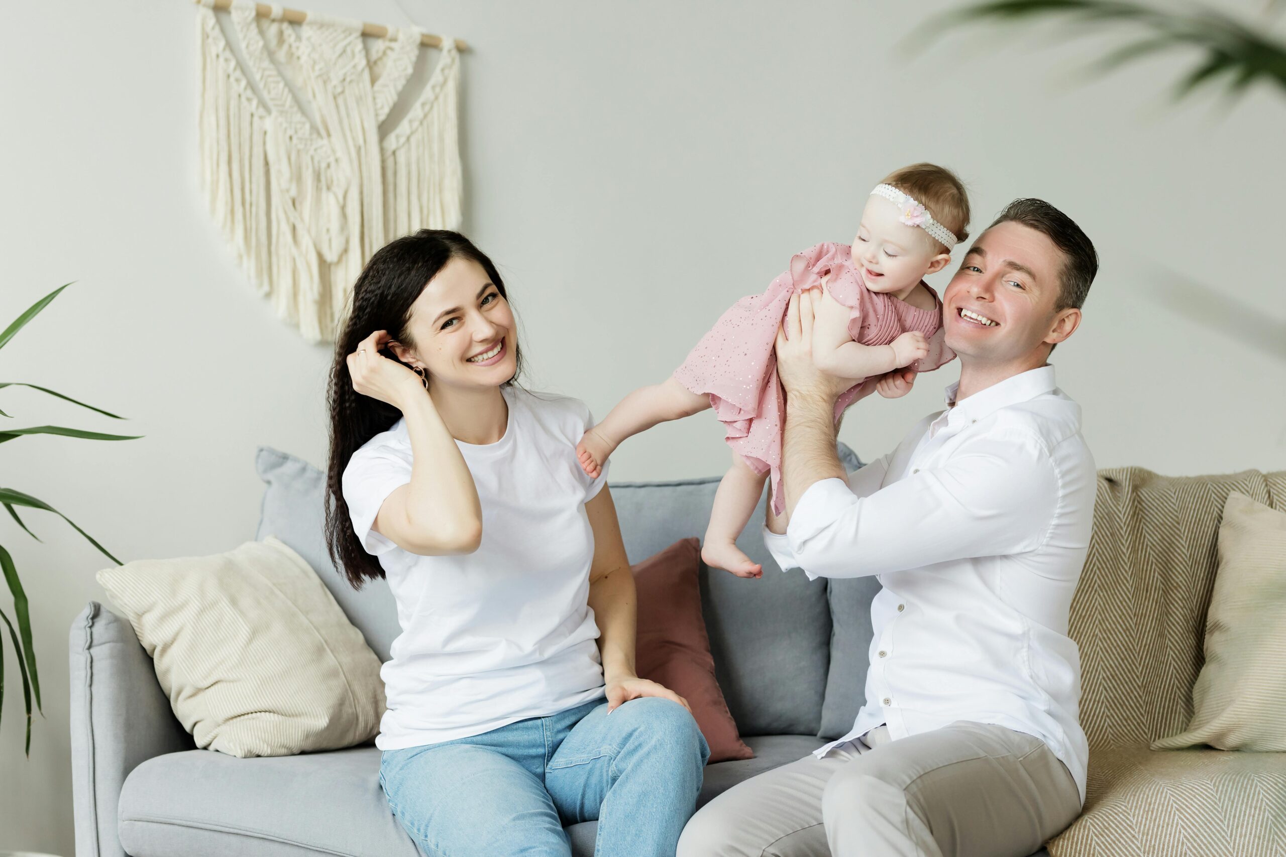 a happy couple playing with their baby girl 