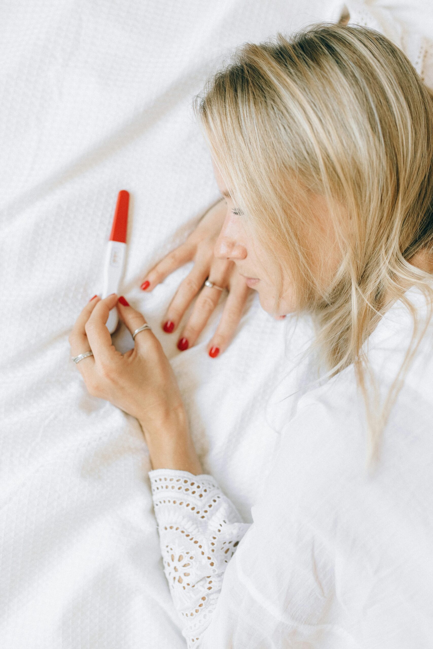 Woman in White Long Sleeve Shirt Holding pragnency test kit 