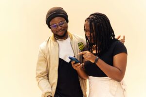 Smiling Couple Using Smartphone in Lagos