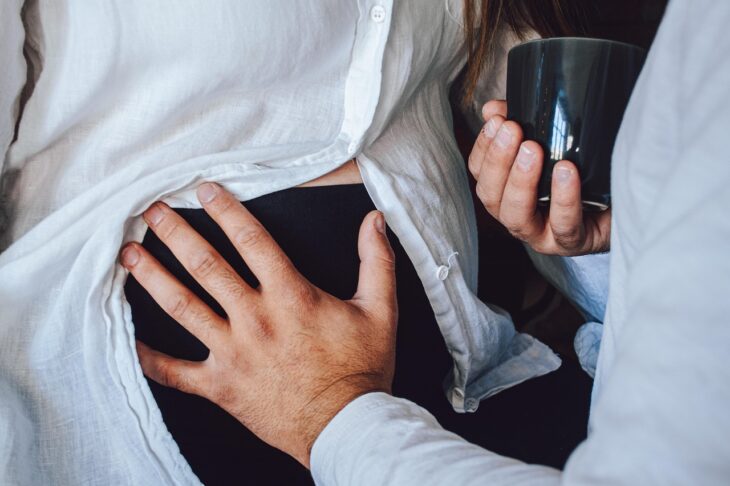 fathers hands on pregnant tummy
