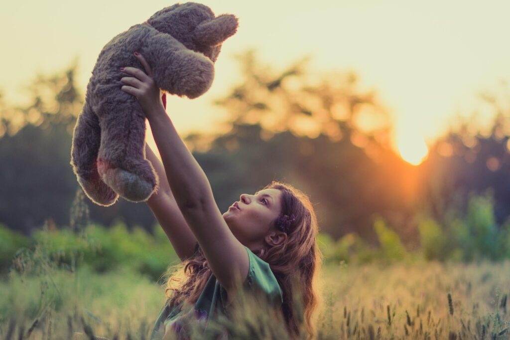 girl playing with teddy bear