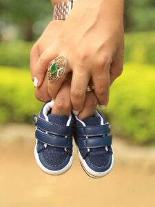 hand holding shoes of a newborn