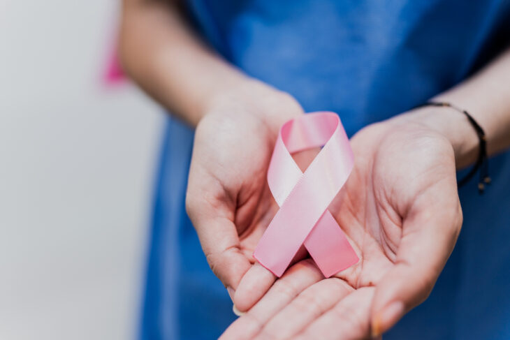 woman patient holding breast cancer ribbon